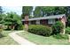Charming brick home featuring a manicured lawn and inviting walkway at 1245 Paddock Cir, Charlotte, NC 28209