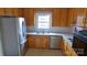 A compact kitchen featuring stainless steel appliances and wood cabinets at 1245 Paddock Cir, Charlotte, NC 28209
