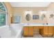 Bright bathroom featuring double sinks, a tub under the window, and a neutral color scheme at 125 Canopy Ct, Mooresville, NC 28115