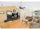 Open-concept living room with hardwood floors, ceiling fan, and entertainment center at 125 Canopy Ct, Mooresville, NC 28115
