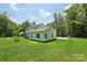 Wide shot of the backyard featuring mature trees, a large green lawn, and a modern home at 127 Wickersham Dr, Statesville, NC 28625