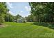 Spacious backyard with lush green grass, mature trees, and outdoor play equipment at 127 Wickersham Dr, Statesville, NC 28625