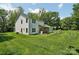 Spacious backyard featuring a lush lawn, mature trees, patio, and play equipment at 127 Wickersham Dr, Statesville, NC 28625