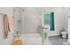 Bright bathroom features a shower-tub with glass enclosure and gray tile flooring at 127 Wickersham Dr, Statesville, NC 28625
