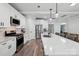 Kitchen boasts stainless steel appliances, white cabinetry, and a quartz island with barstool seating at 127 Wickersham Dr, Statesville, NC 28625