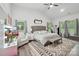 Main bedroom features a gray bed, a ceiling fan, natural light, and neutral decor at 127 Wickersham Dr, Statesville, NC 28625