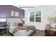 Cozy bedroom boasts a lilac accent wall, plush bedding, and a side table with lamp and plants at 130 Parker Claire Ln, Kings Mountain, NC 28086