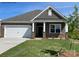 Charming single-story home with stone and brown shingle exterior, complemented by a well-manicured lawn at 130 Parker Claire Ln, Kings Mountain, NC 28086