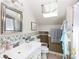Bright bathroom featuring a white vanity, floral wallpaper, a skylight, and a shower-tub combination at 1371 Hawks Nest Rd, York, SC 29745