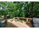 Outdoor deck with wood flooring, black railings, and flower pots with a beautiful view of wooded backyard at 1371 Hawks Nest Rd, York, SC 29745