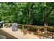 Spacious outdoor deck featuring wood flooring, black railings, grill and beautiful view of wooded backyard at 1371 Hawks Nest Rd, York, SC 29745