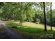 Gravel driveway winds through a lush green lawn and mature trees at 1371 Hawks Nest Rd, York, SC 29745