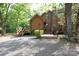 Charming home featuring a stone chimney, inviting front porch, and an expansive wooden deck amidst lush greenery at 1371 Hawks Nest Rd, York, SC 29745