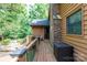 Side porch featuring wood flooring, a brick chimney, and access to the home's rear entrance at 1371 Hawks Nest Rd, York, SC 29745