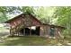 Barn featuring a staircase to a small balcony, a drive-through, and an enclosed area with a green door at 1371 Hawks Nest Rd, York, SC 29745