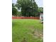 Expansive backyard featuring lush green grass and a charming red wooden fence at 1510 Stoker Ter, Albemarle, NC 28001