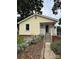 Inviting yellow house with a front porch, flowers, and landscaped garden along walkway at 1510 Stoker Ter, Albemarle, NC 28001