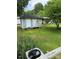 Outdoor outbuilding in the backyard, surrounded by green grass and trees at 1510 Stoker Ter, Albemarle, NC 28001