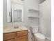 Practical bathroom with a classic sink, toilet, and a shower featuring storage shelves, blending function and simplicity at 152 Hampshire Dr, Mooresville, NC 28115