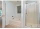 Bright bathroom featuring a bathtub under a window and a glass-enclosed shower, offering a relaxing spa-like experience at 152 Hampshire Dr, Mooresville, NC 28115
