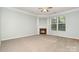 Cozy living room showcasing a fireplace, large window, and neutral colored carpeting at 152 Hampshire Dr, Mooresville, NC 28115