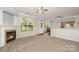 Inviting living room with a fireplace, neutral carpeting, and an abundance of natural light at 152 Hampshire Dr, Mooresville, NC 28115