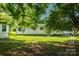 View of shady backyard and a detached shed with a brick path at 1613 Hamilton St, Charlotte, NC 28206