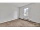 Bedroom featuring a window, neutral carpet, and baseboard heating at 1613 Hamilton St, Charlotte, NC 28206