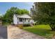 Charming home with front porch, brick foundation, manicured lawn and mature tree at 1613 Hamilton St, Charlotte, NC 28206