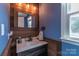 Modern bathroom with wood accent wall, stylish mirror and fixtures and natural light from the window at 1739 Lesa Lin Dr, Monroe, NC 28112