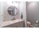 Well lit bathroom with white vanity, round mirror, and tile accents at 1739 Lesa Lin Dr, Monroe, NC 28112