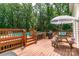 Elevated deck with stairs and railings, grill, umbrella, and seating area at 1739 Lesa Lin Dr, Monroe, NC 28112