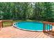 Above ground pool with ladder surrounded by a wooden deck at 1739 Lesa Lin Dr, Monroe, NC 28112
