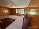 Cozy living room with wood paneling, fireplace, carpet, and ample natural light, creating a warm and inviting atmosphere at 1821 Beaman St, Shelby, NC 28152