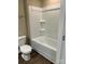 Bathroom showcasing a modern bathtub with shower, complemented by a toilet and wood-look flooring at 183 Pine Haven Rd, Statesville, NC 28677