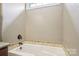 Bright bathroom featuring a tiled tub with jacuzzi jets and chrome fixtures at 2021 Chantilly Ln, Salisbury, NC 28146