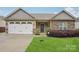 Charming exterior of home with garage, stone accents and manicured lawn at 2021 Chantilly Ln, Salisbury, NC 28146