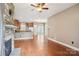 Open-concept layout featuring a stone fireplace, wood floors, and seamless flow to the kitchen at 2021 Chantilly Ln, Salisbury, NC 28146