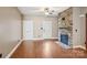 Cozy living room featuring hardwood floors, a stone fireplace, and a white front door at 2021 Chantilly Ln, Salisbury, NC 28146