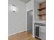 Cozy entryway with a gray door, a brick wall with wooden shelves, and a modern wine refrigerator at 210 N Church St # 2910, Charlotte, NC 28202