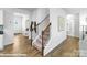 Hallway with hardwood floors, carpeted staircase, and a view of the front door and nearby bathroom at 221 Paige Rd, Kings Mountain, NC 28086