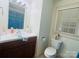 The bathroom features a white toilet, white sink and vanity, and a window with blinds at 2357 28Th Ne St, Hickory, NC 28601