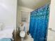 A bathroom features a toilet, shower with a blue shower curtain, and a window at 2357 28Th Ne St, Hickory, NC 28601