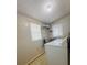 A small laundry room features white machines, overhead light, and a built in shelf at 2357 28Th Ne St, Hickory, NC 28601