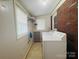 This is a laundry room with white machines and a large brick wall at 2357 28Th Ne St, Hickory, NC 28601