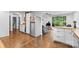Open concept kitchen with stainless steel refrigerator, white cabinetry, and hardwood floors at 2536 Bancroft St, Charlotte, NC 28206