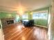 Comfortable living area with wood floors, a stone fireplace, and lots of natural light from the bright green walls at 2601 Marldale St, Gastonia, NC 28052
