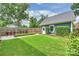 A fenced backyard with a manicured lawn, garden, and a detached garage with a white door at 2829 Holt St, Charlotte, NC 28205
