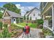Lush backyard featuring a well-manicured lawn, vibrant flowerbeds, detached garage, and a patio at 2829 Holt St, Charlotte, NC 28205