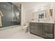 Well-lit bathroom with updated vanity, elegant mirror, and tub-shower combination at 2829 Holt St, Charlotte, NC 28205